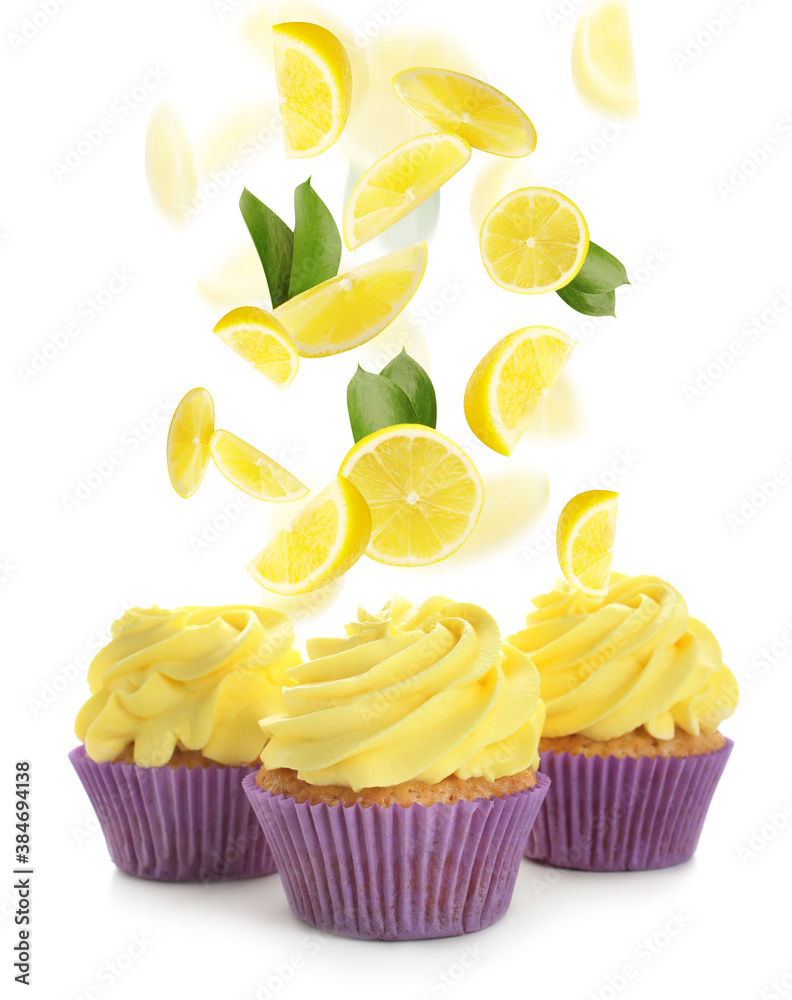 Delicious cupcakes and falling cut lemon on white background