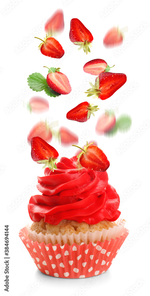 Tasty cupcake and falling strawberry on white background