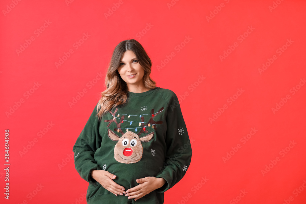 Beautiful pregnant woman on color background. Christmas celebration