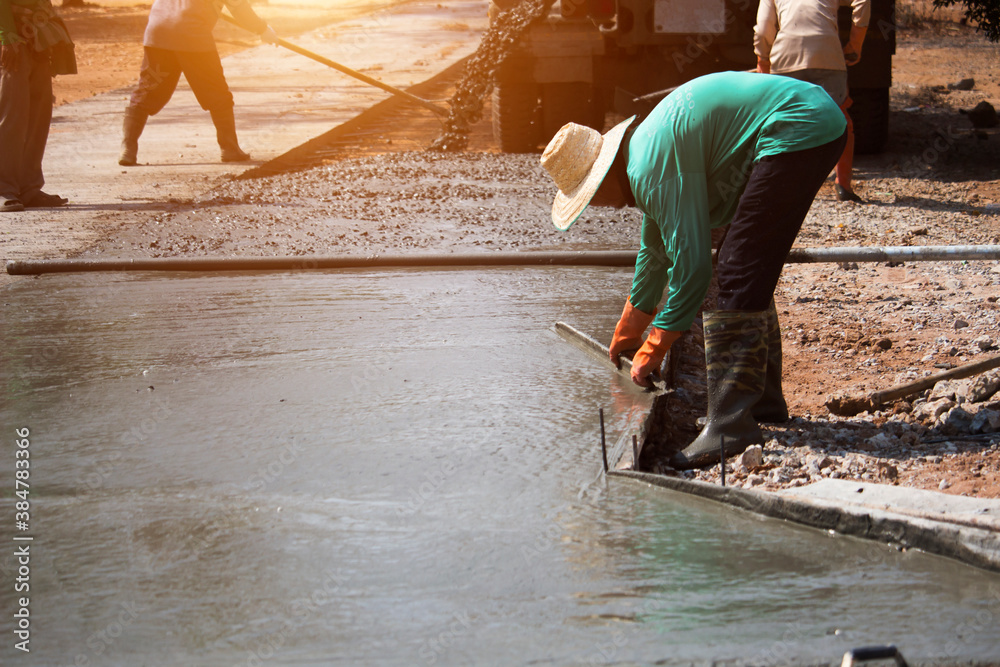 Workers pouring concrete with a cement mixer truck