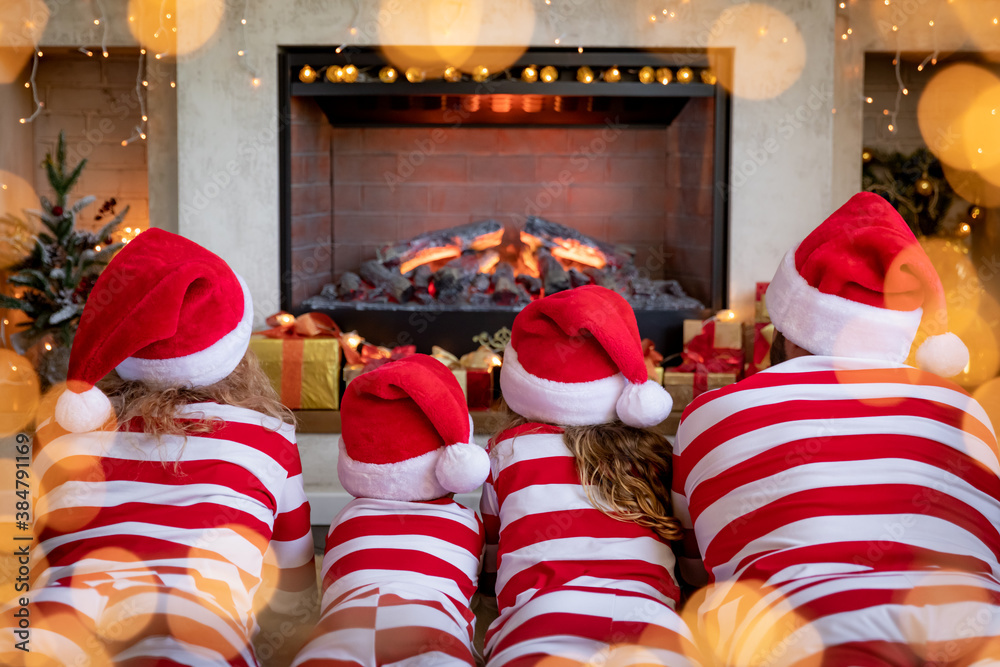 Happy family with children near fireplace at Christmas