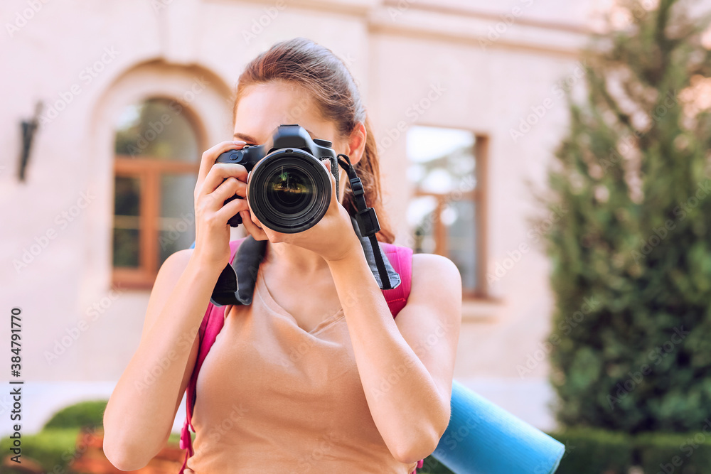 Female tourist taking photo on city street