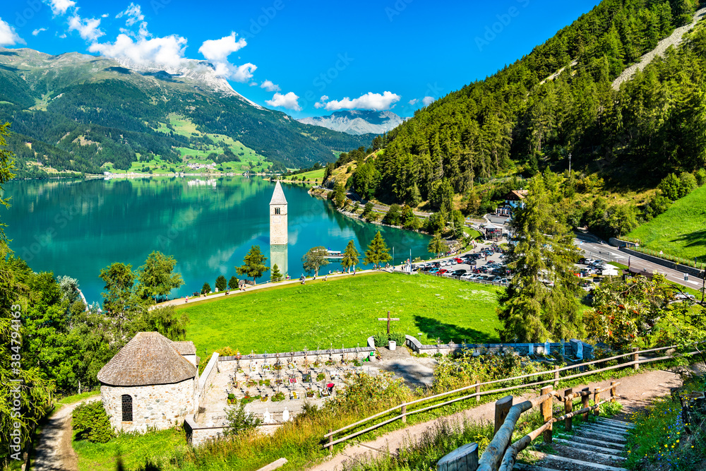 Submerged Bell Tower of Curon and a graveyard at Graun im Vinschgau on Lake Reschen in South Tyrol, 