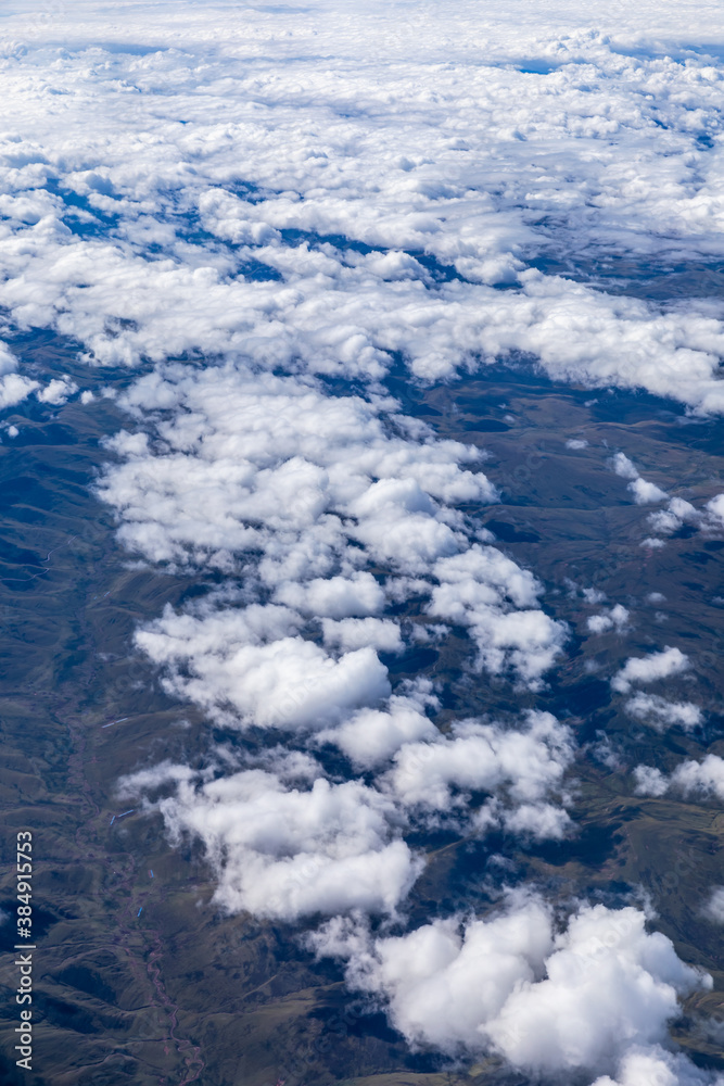 Aerial view above the clouds and mountain peaks on a sunny day.mountain view from airplane.