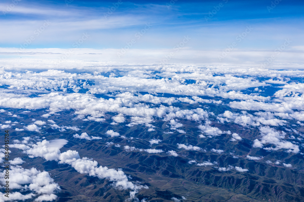 Aerial view above the clouds and mountain peaks on a sunny day.mountain view from airplane.