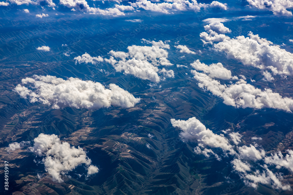 Aerial view above the clouds and mountain peaks on a sunny day.mountain view from airplane.