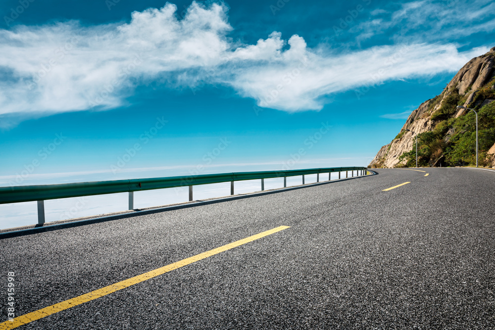 Empty asphalt road and blue sky with white clouds scenery.