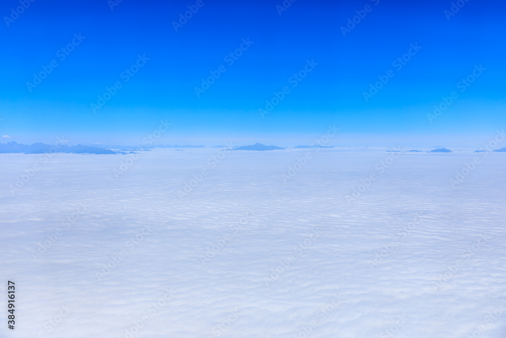 Aerial view above the clouds and mountain peaks on a sunny day.mountain view from airplane.