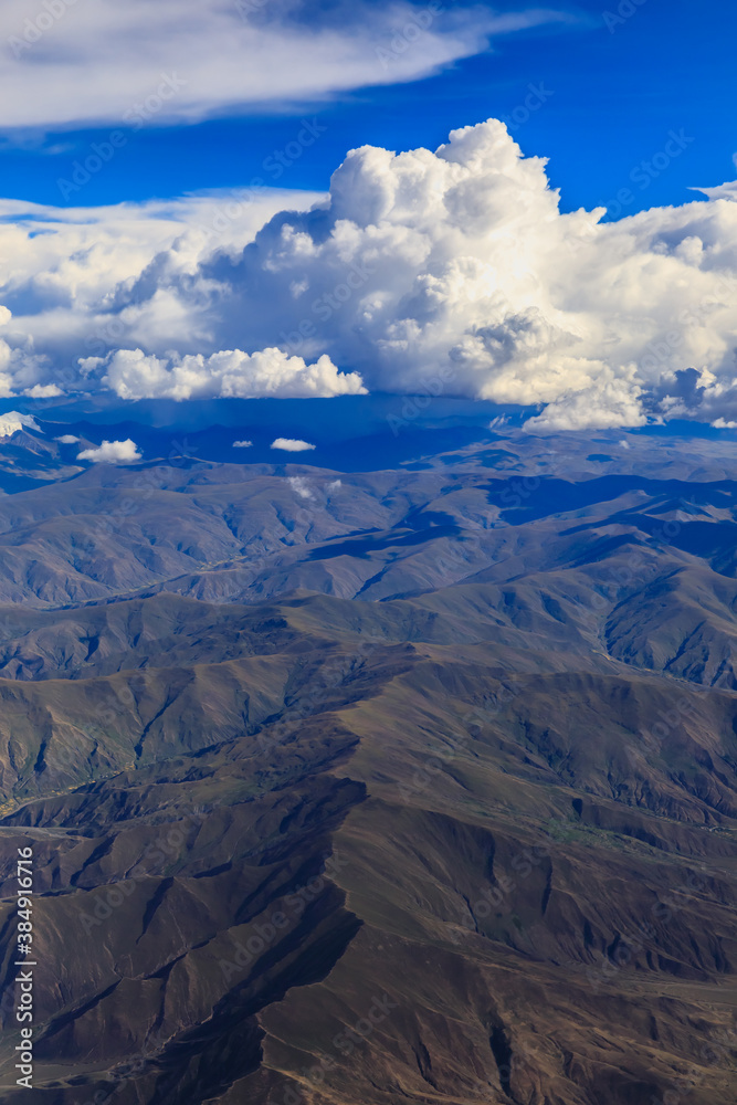 Aerial view above the clouds and mountain peaks on a sunny day.mountain view from airplane.