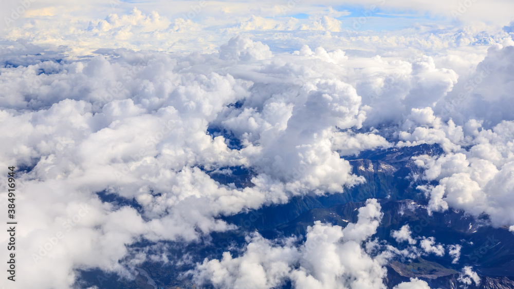 Aerial view above the clouds and mountain peaks on a sunny day.mountain view from airplane.