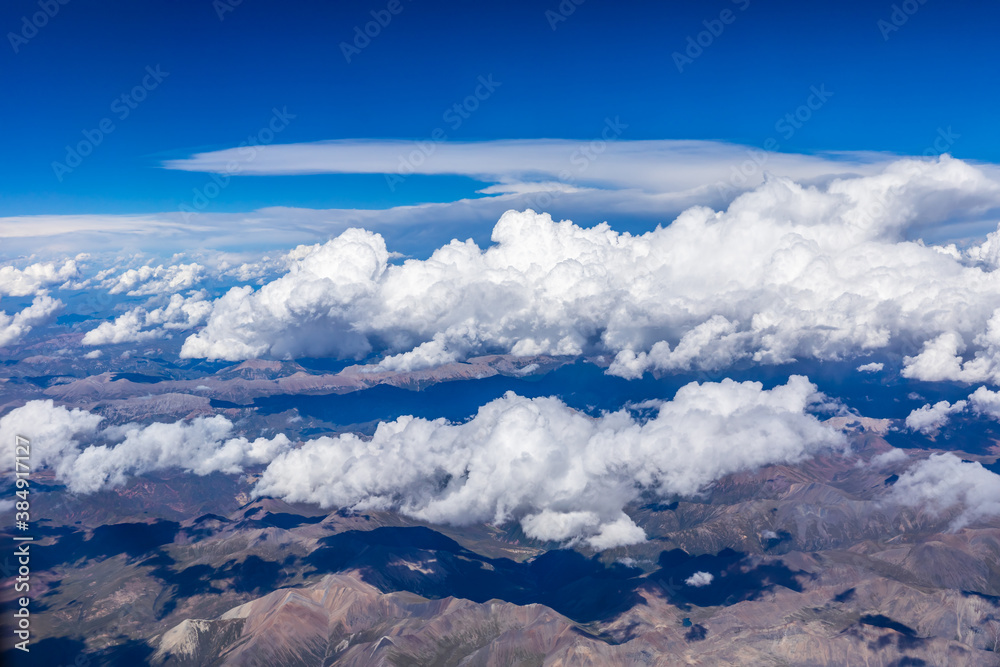 Aerial view above the clouds and mountain peaks on a sunny day.mountain view from airplane.