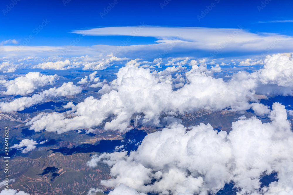 Aerial view above the clouds and mountain peaks on a sunny day.mountain view from airplane.