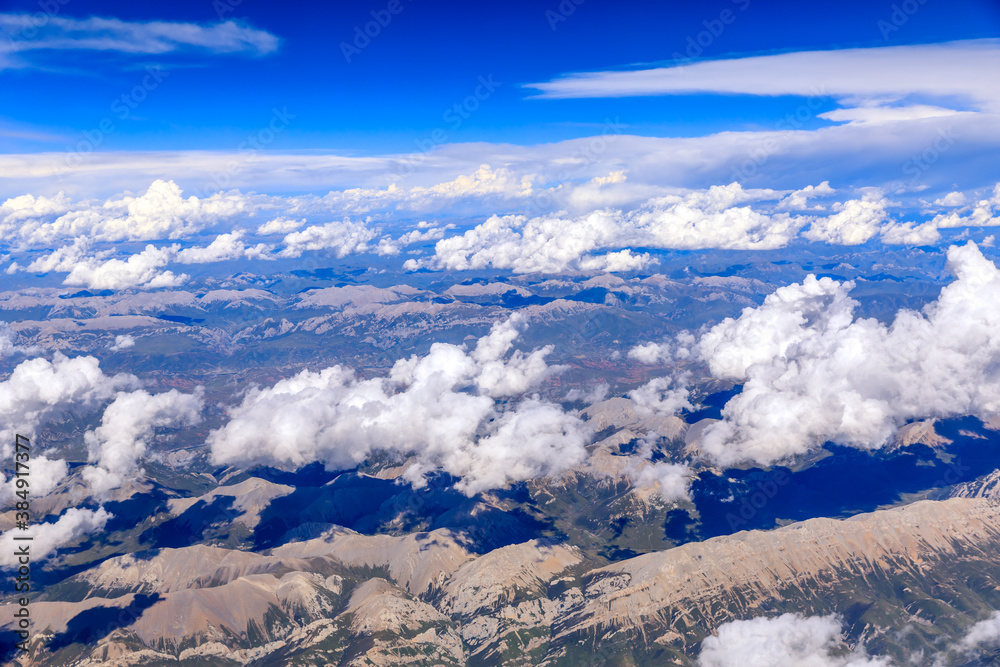 Aerial view above the clouds and mountain peaks on a sunny day.mountain view from airplane.