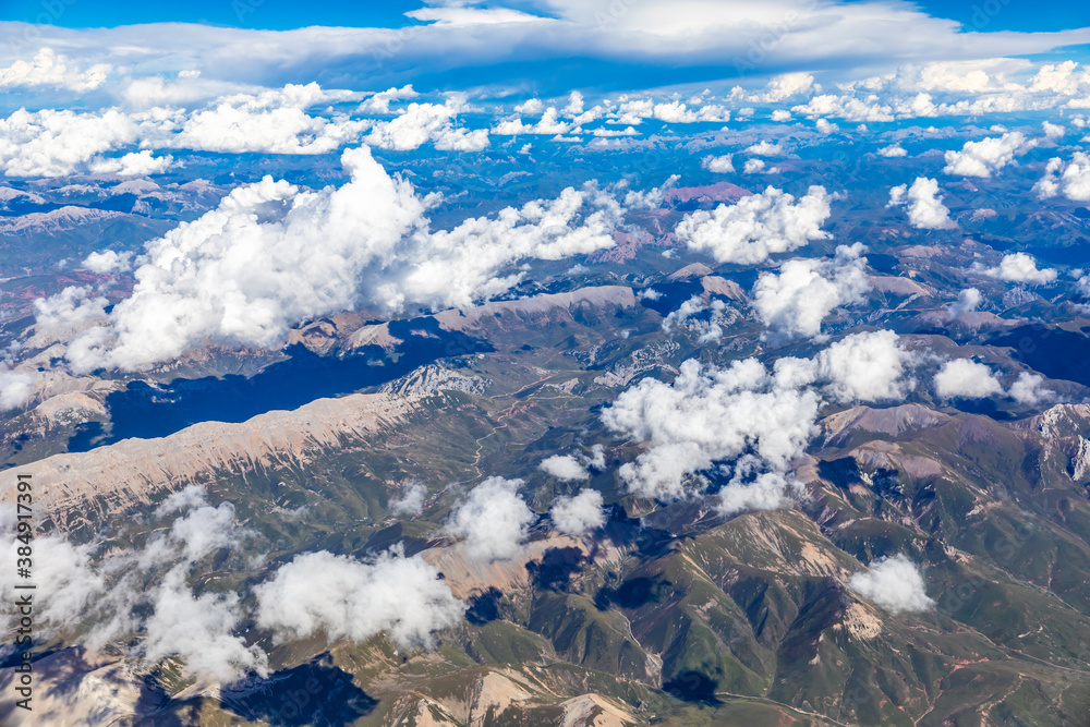 Aerial view above the clouds and mountain peaks on a sunny day.mountain view from airplane.