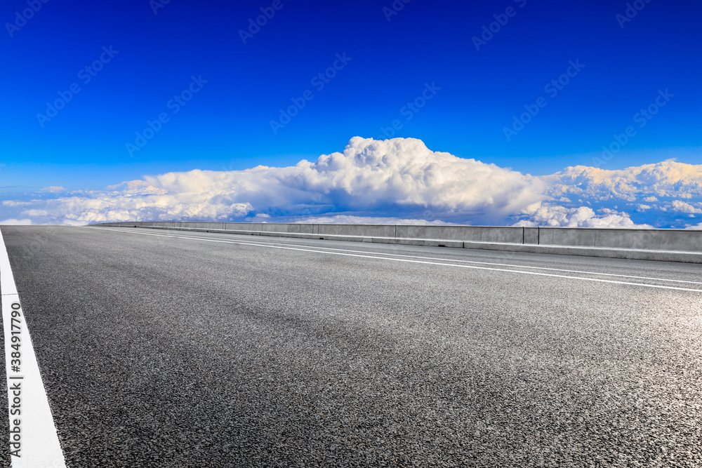 Empty asphalt road and blue sky with white clouds scenery.