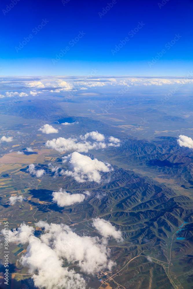 Aerial view above the clouds and mountain peaks on a sunny day.mountain view from airplane.