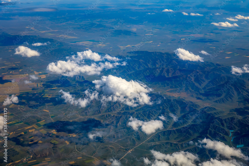 Aerial view above the clouds and mountain peaks on a sunny day.mountain view from airplane.