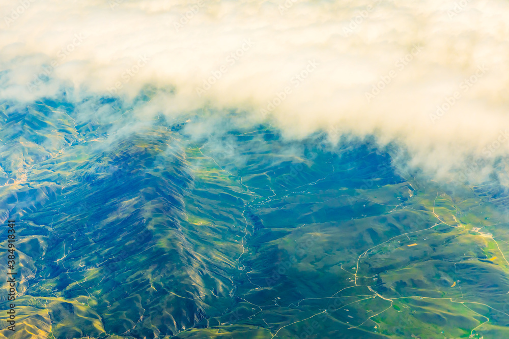 Aerial view above the clouds and mountain peaks on a sunny day.mountain view from airplane.