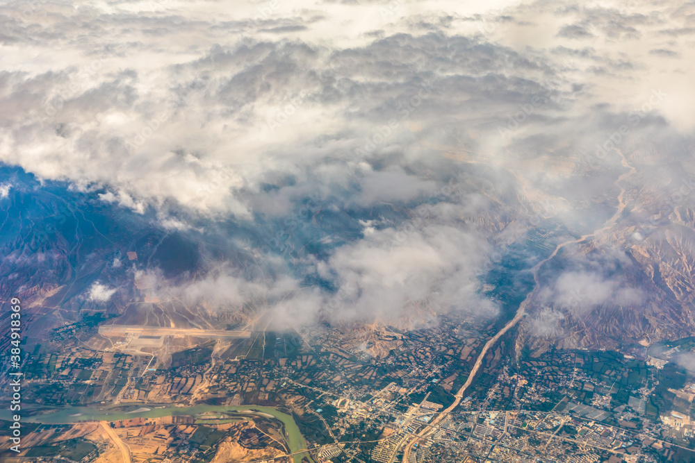 Aerial view above the clouds and mountain peaks on a sunny day.mountain view from airplane.