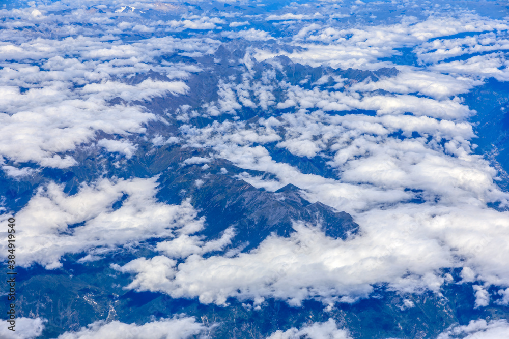 Aerial view above the clouds and mountain peaks on a sunny day.mountain view from airplane.