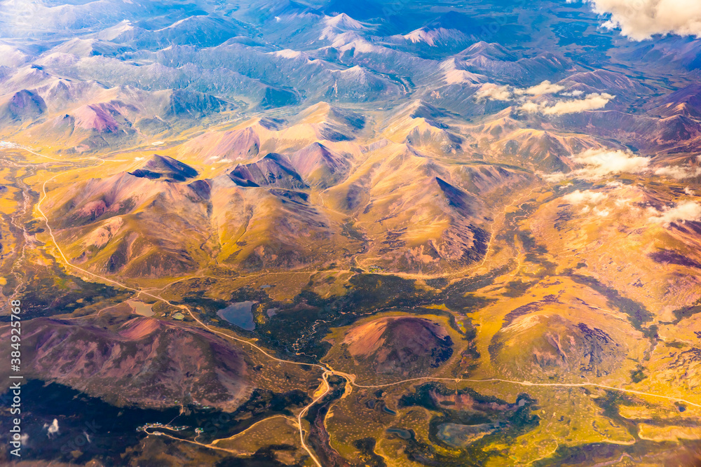 Aerial view above the clouds and colorful mountain on a sunny day.mountain view from airplane.