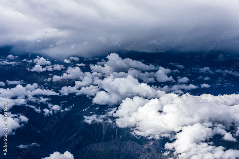 Aerial view above the clouds and mountain peaks on a sunny day.mountain view from airplane.