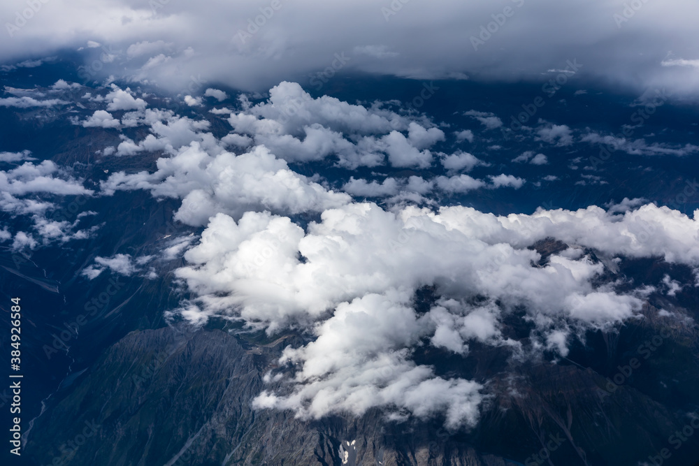 Aerial view above the clouds and mountain peaks on a sunny day.mountain view from airplane.