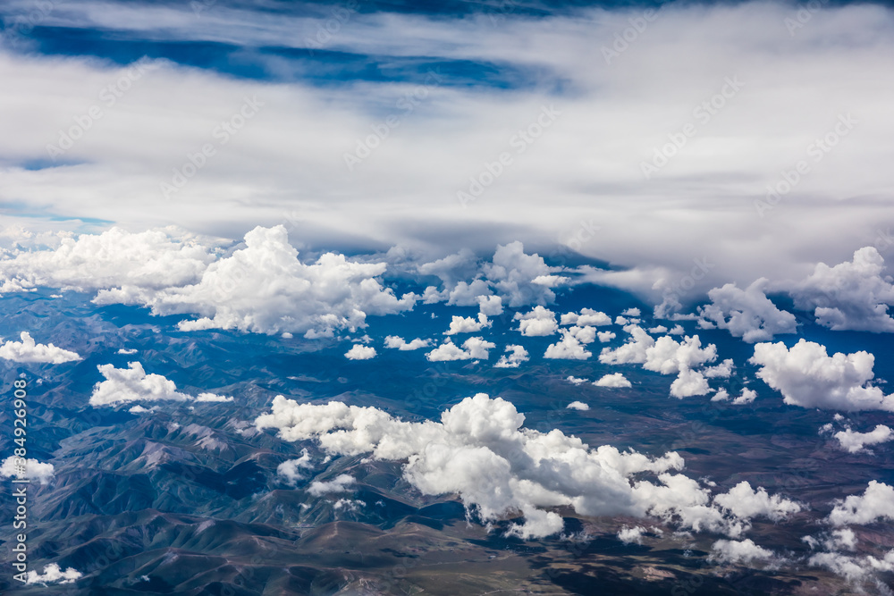 Aerial view above the clouds and mountain peaks on a sunny day.mountain view from airplane.