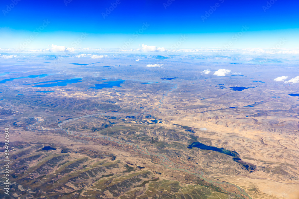 Aerial view above the clouds and mountain peaks on a sunny day.mountain view from airplane.