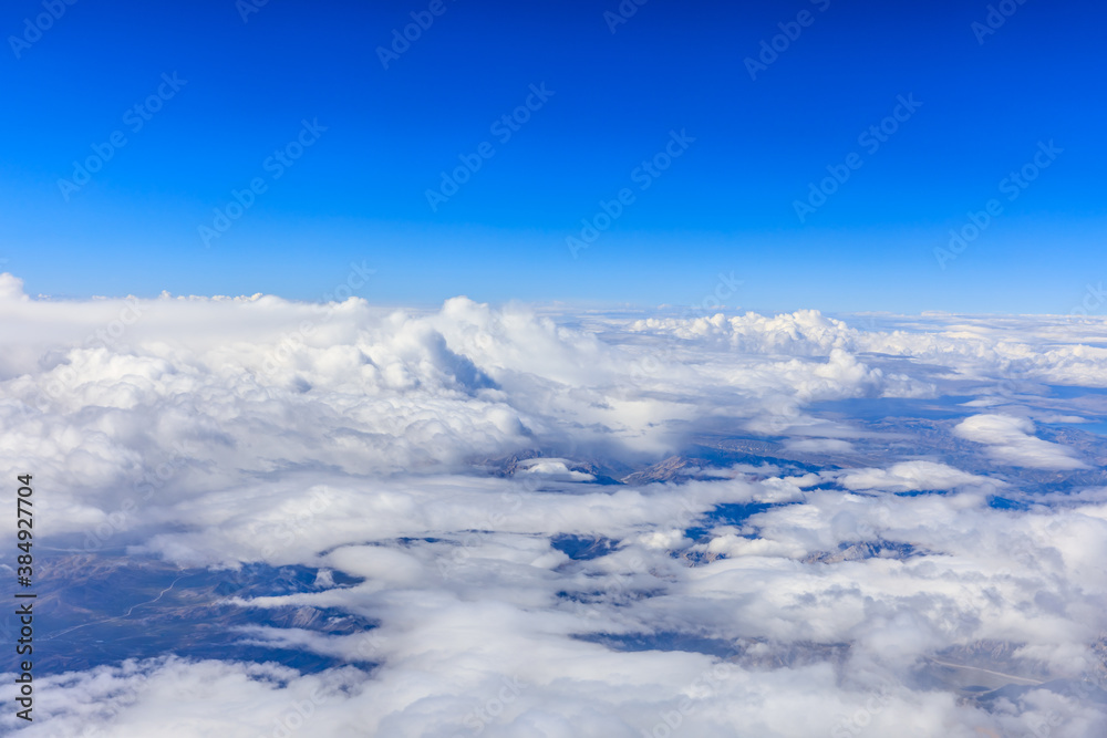 Aerial view above the clouds and mountain peaks on a sunny day.mountain view from airplane.