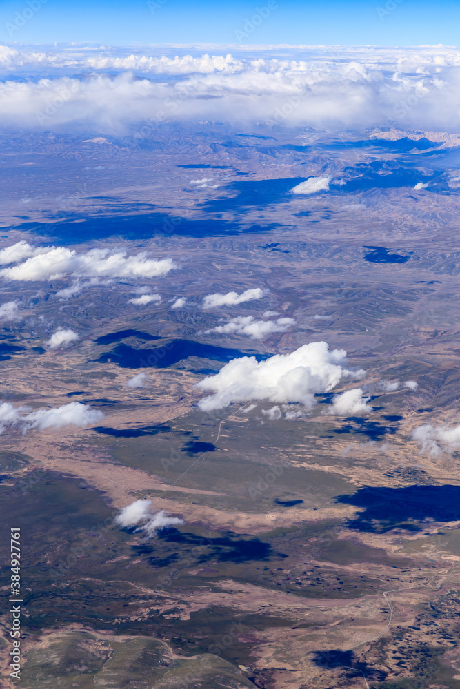 Aerial view above the clouds and mountain peaks on a sunny day.mountain view from airplane.