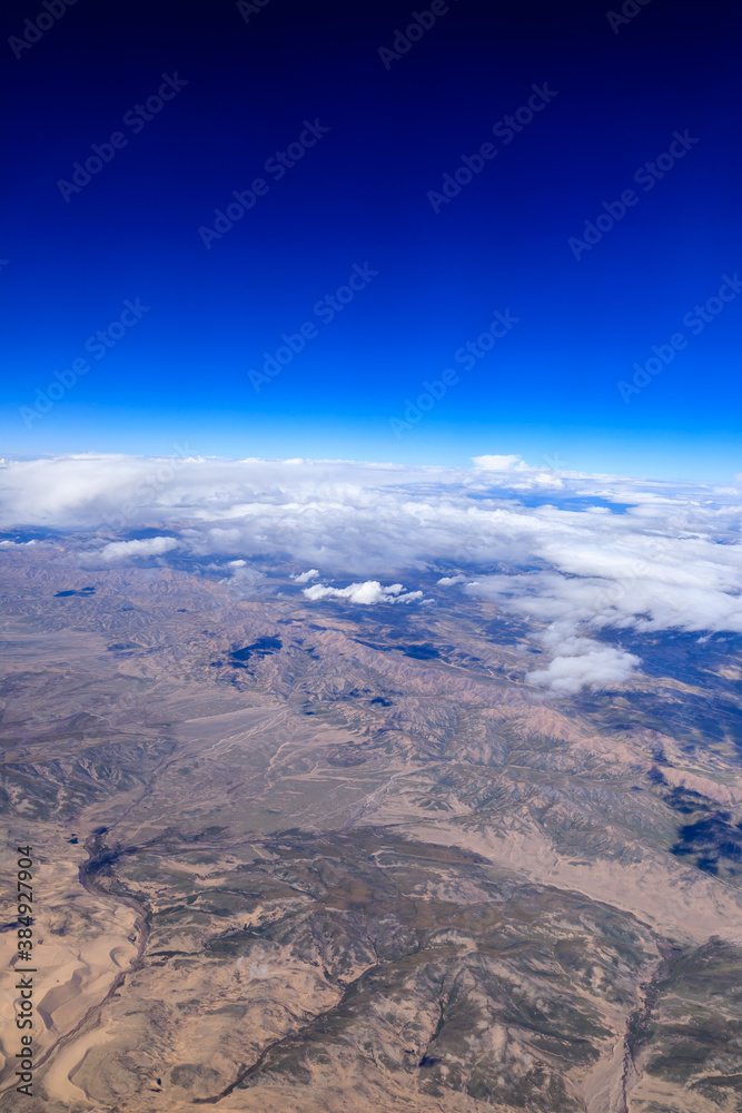 Aerial view above the clouds and mountain peaks on a sunny day.mountain view from airplane.