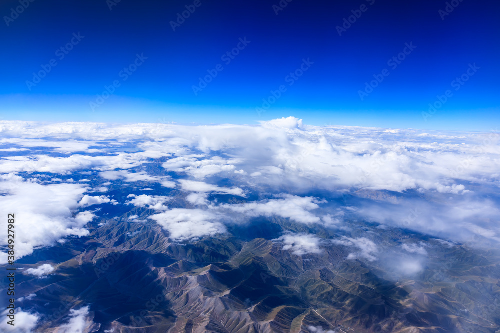 Aerial view above the clouds and mountain peaks on a sunny day.mountain view from airplane.