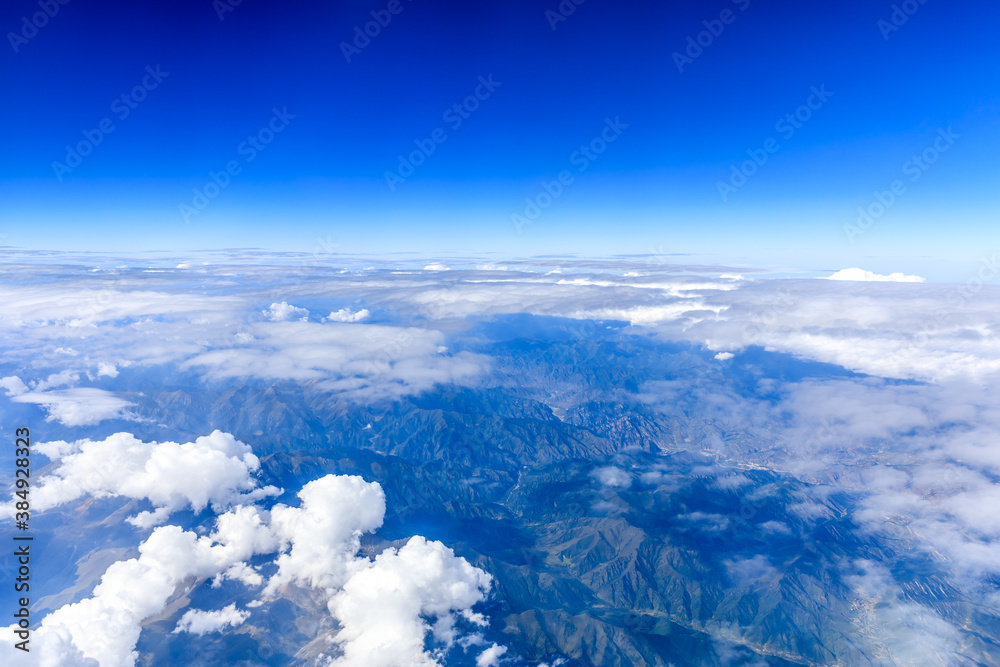 Aerial view above the clouds and mountain peaks on a sunny day.mountain view from airplane.