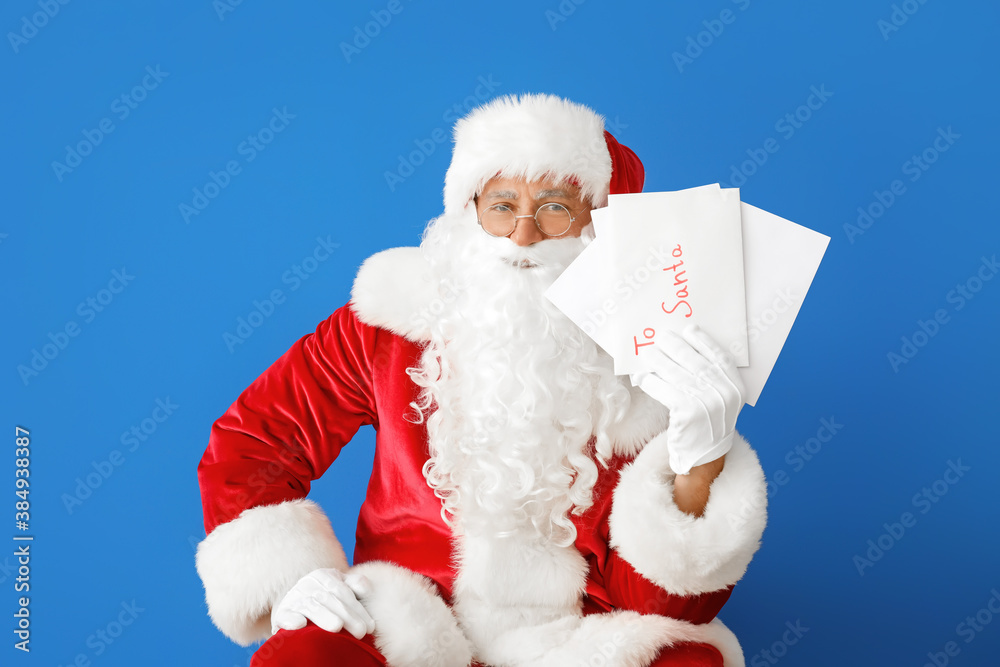 Santa Claus with letters on color background