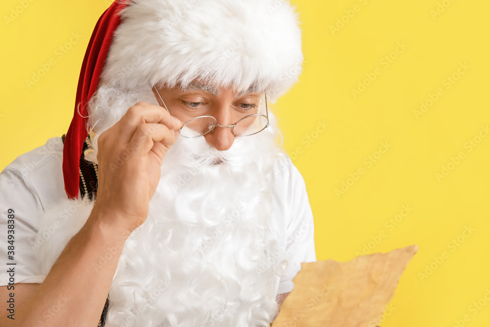 Santa Claus reading letter on color background