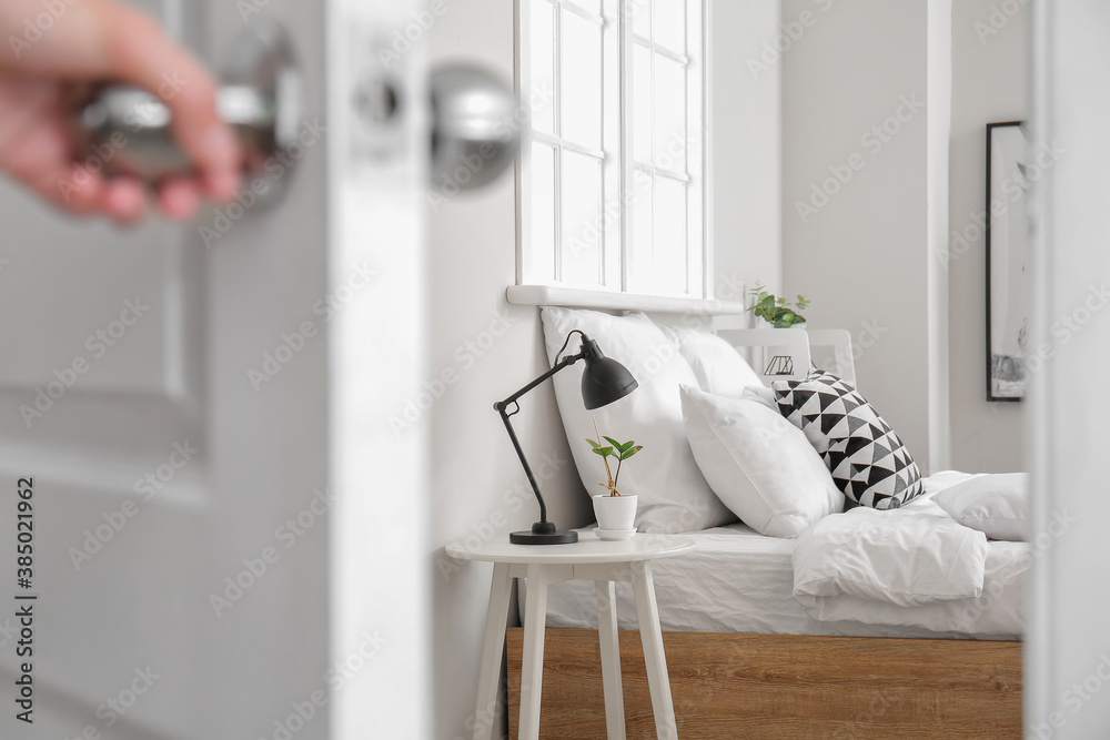 Woman opening door in modern bedroom