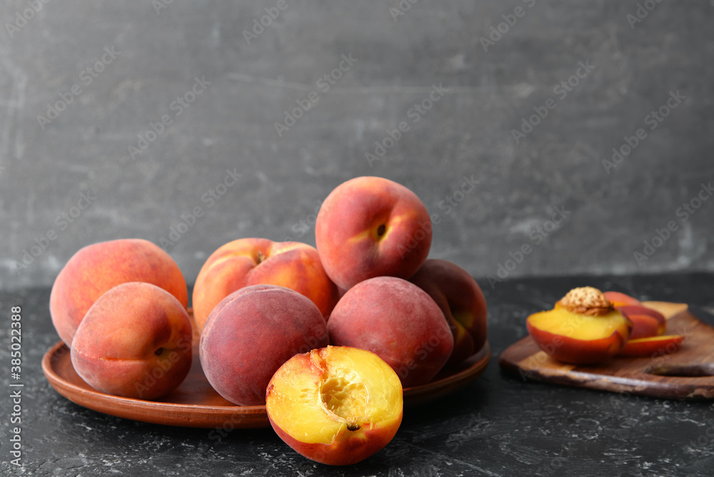 Plate with sweet peaches on table