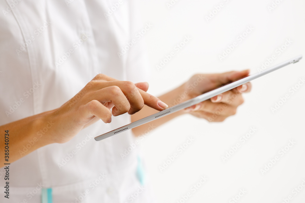 tablet wireless computer in the hands of a doctor in a white uniform