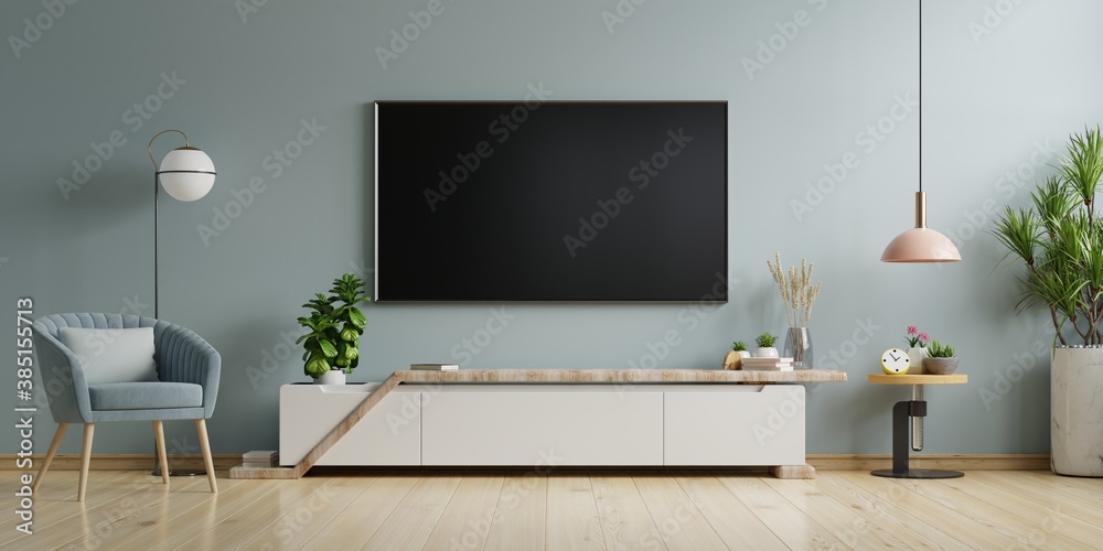 TV on the cabinet in modern living room on blue wall background.