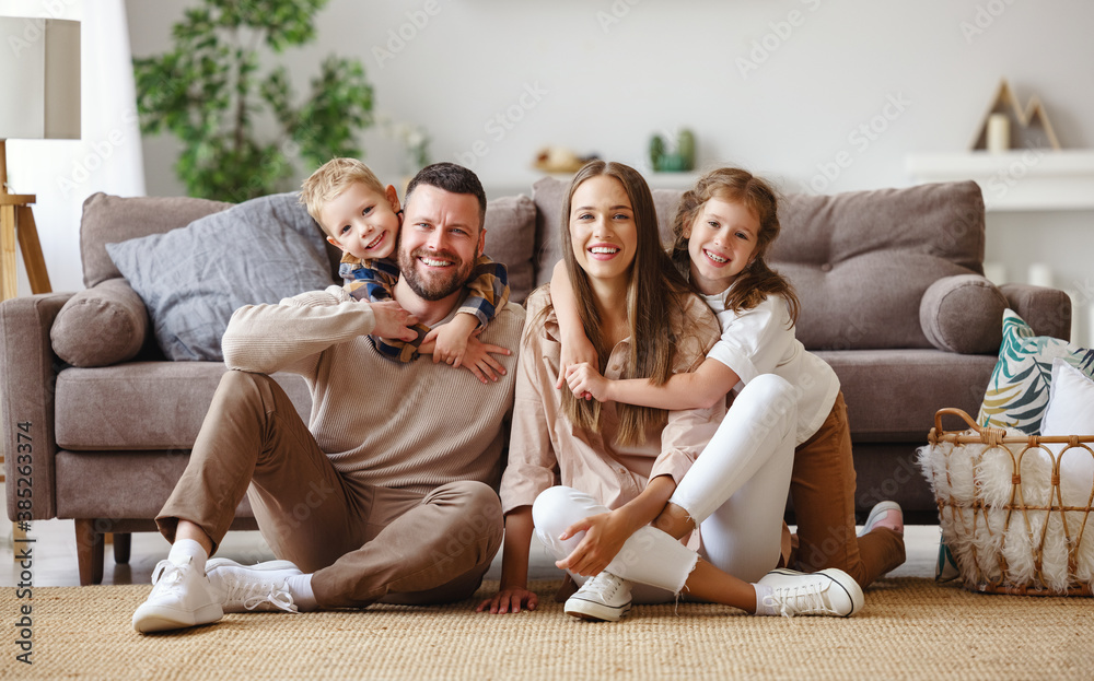 happy family mother father and children at home on couch .