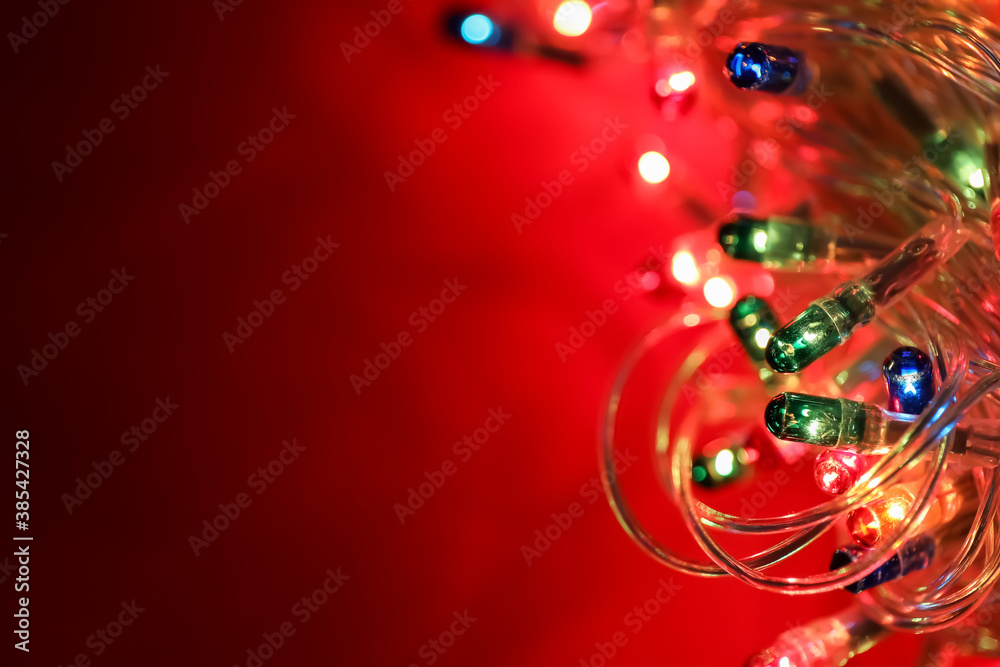 Glowing Christmas lights on color background