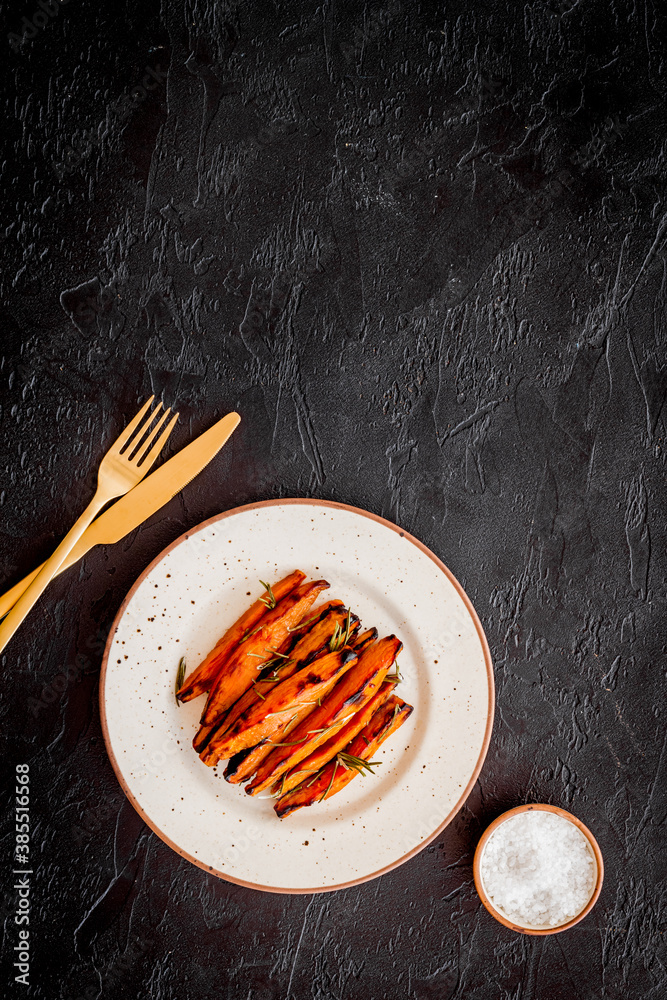 Pile of sweet potato fries with herbs on a plate, top view