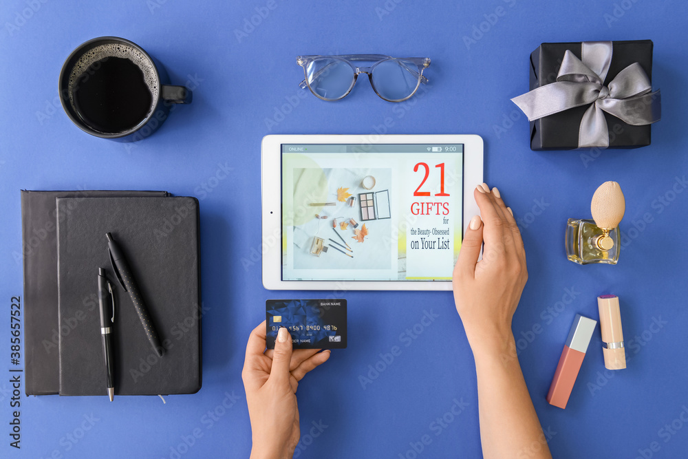 Woman with tablet computer shopping online on color background, top view