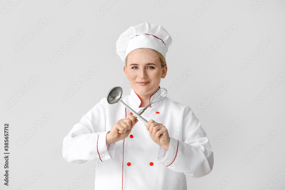 Mature female chef on grey background