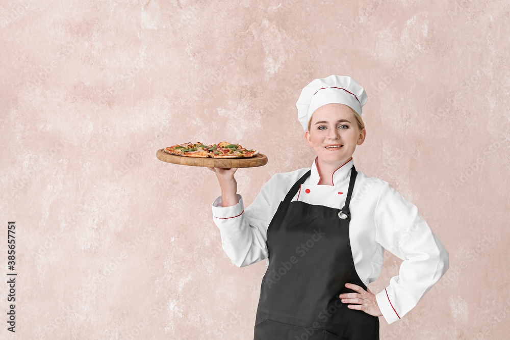 Mature female chef with tasty pizza on color background