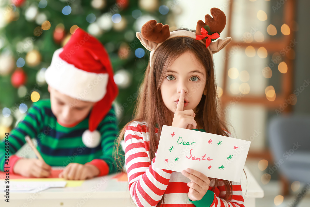 Little children writing letters to Santa at home on Christmas eve