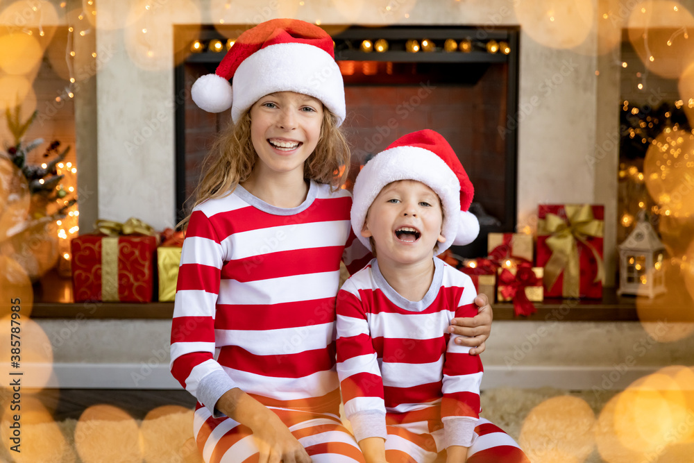 Happy children near fireplace at Christmas