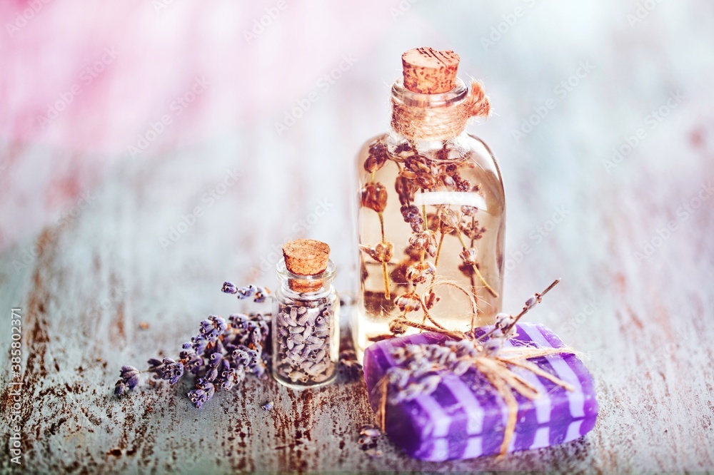 Pile of lavender flowers and a dropper bottle with lavender essence