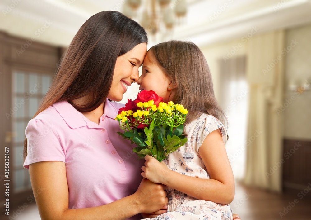 Happy Mother and daughter hugging with flowers